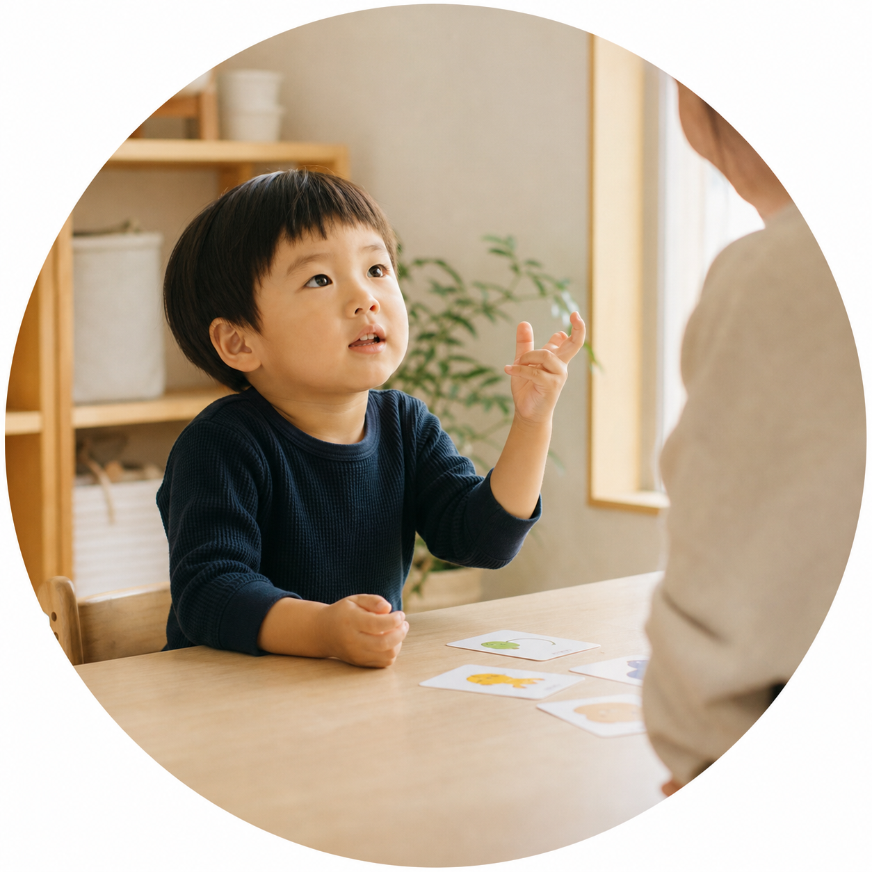 写真カードを前に、保護者へ身振りで伝える子ども